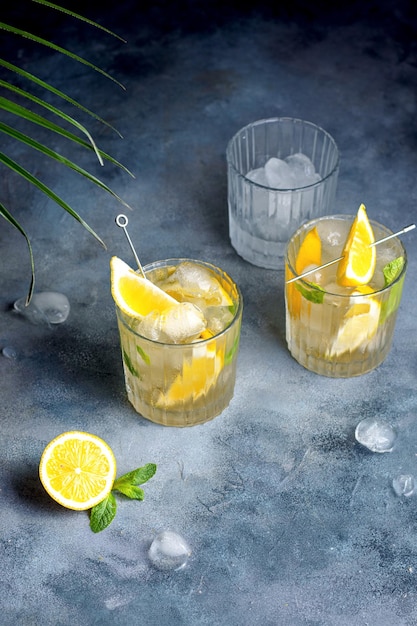 Foto limonata di agrumi con menta e limone nel bicchiere con cubetti di ghiaccio