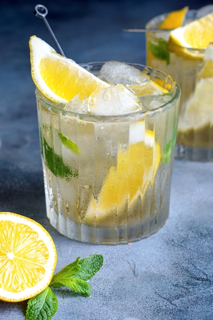 Citrus lemonade with mint and lemon in the glass with ice cubes