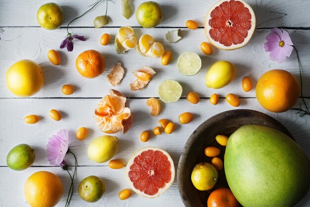 Photo citrus mix on the white wooden background top view