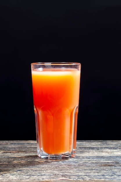 赤く熟したジューシーなグレープフルーツからの柑橘系の天然本物のジュース
