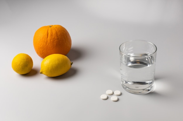 Citruses, a glass of water and medicines