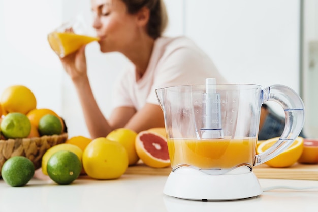 Citruspers en vrouw die vers geperst zelfgemaakte sinaasappelsap drinken?