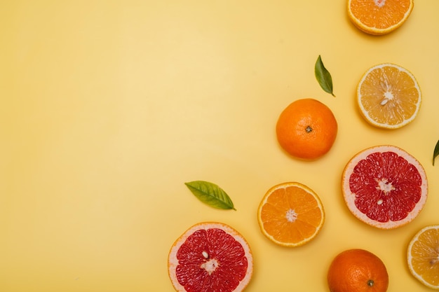 Citrusvruchten op een gele achtergrond met copyspace fruit flatley een zomerse minimalistische compositie met grapefruit, citroen, mandarijn en sinaasappel