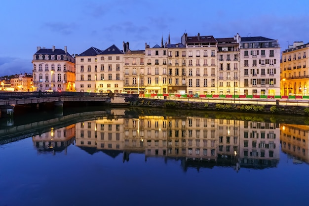 夜のフランスのバイヨンヌ市。典型的な建築物の家々とアドゥー川の反射。ヨーロッパ。