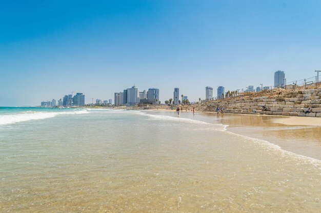 City buildings by sea against clear sky