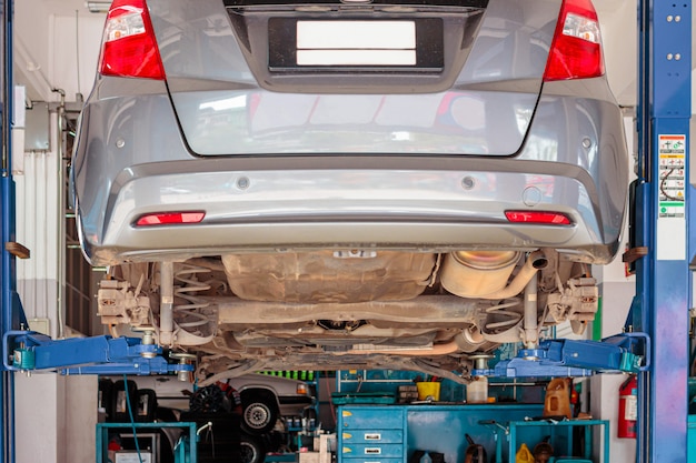 City car in the lifting equipment in the garage being repair and fix, Concept of car fixing. 