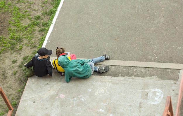 City children in the yard play a game on the phone. 