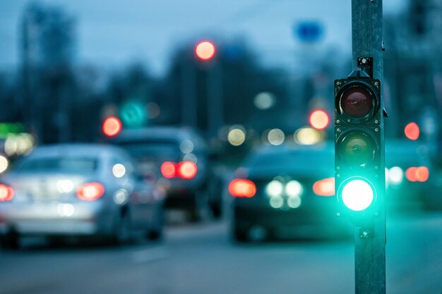 저녁 거리에서 자동차와 함께 흐릿한 배경에 세마포르와 함께 도시 교차 녹색 빛