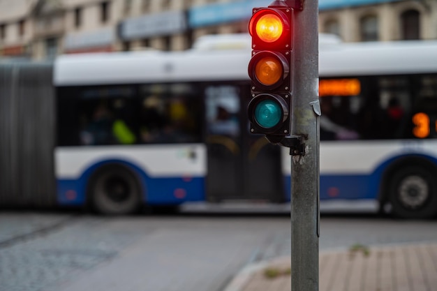 a city crossing with a semaphore on blurred background with cars in the evening streets red light