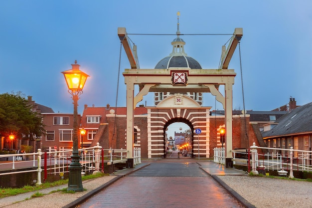 Foto porta della città e ponte morspoort a leiden durante l'ora blu olanda meridionale paesi bassi