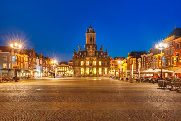 Il municipio e le tipiche case olandesi sulla piazza markt nel centro della città vecchia di notte, delft, olanda, paesi bassi