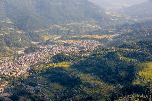 A city is surrounded by mountains and the mountains are surrounded by greenery.