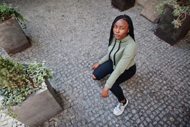 Photo city portrait of positive young dark skinned female wearing green hoody