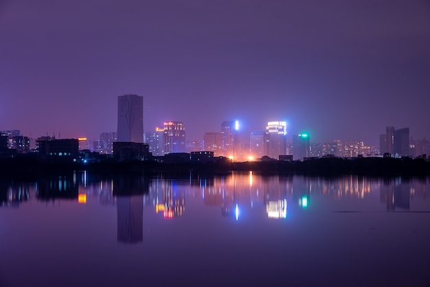 A city reflected by the lake at night
