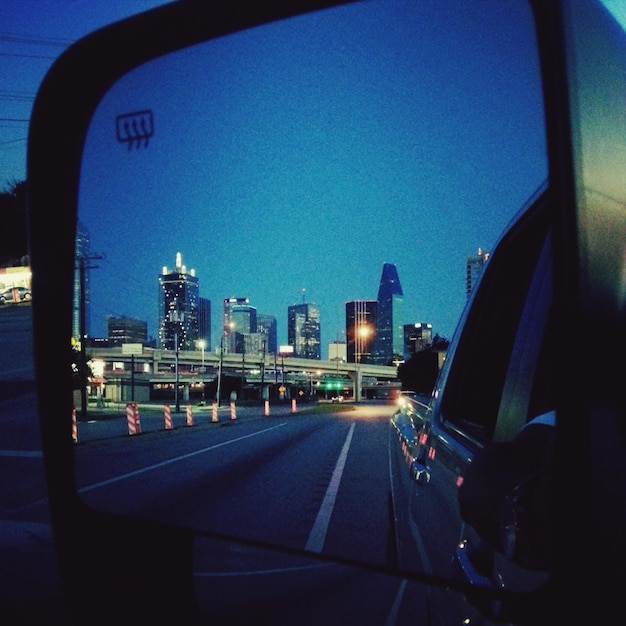 Foto la città riflessa nello specchio laterale dell'auto