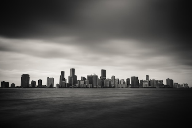 Photo city skyline by sea against cloudy sky