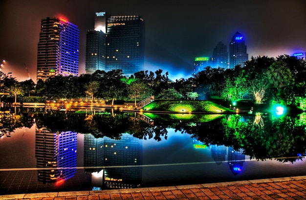 a city skyline with a reflection of a city in the water