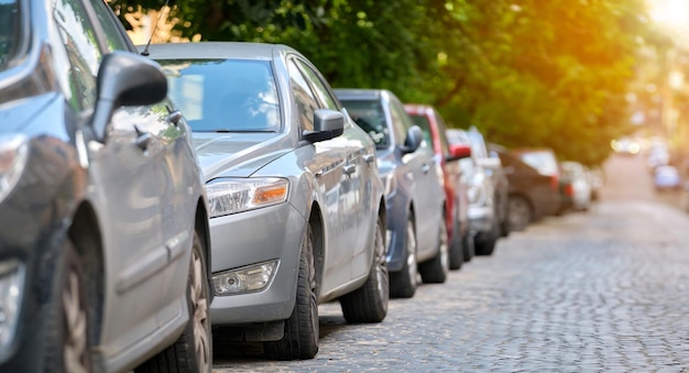 City traffic with cars parked in line on street side.