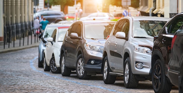 Traffico cittadino con auto parcheggiate in fila lato strada