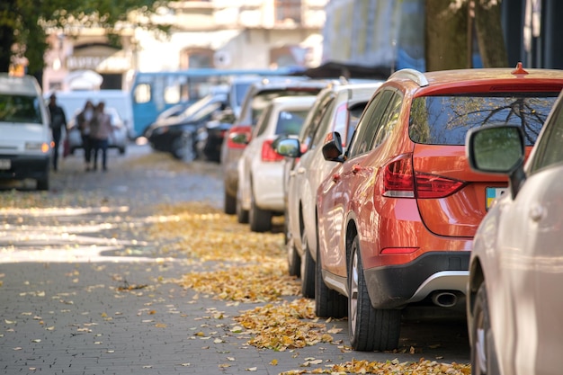 Traffico cittadino con molte auto parcheggiate in fila sul lato strada