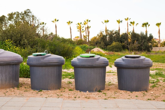 City trash cans. green overfilled trash dumpster