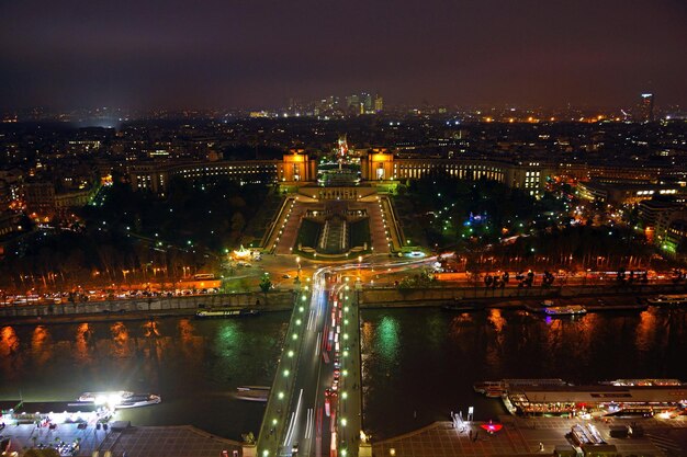 Photo a city view of a city at night with a bridge and a river