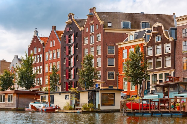 Фото Городской вид на канал амстердама и типичные дома, лодки и велосипеды, голландия, нидерланды.