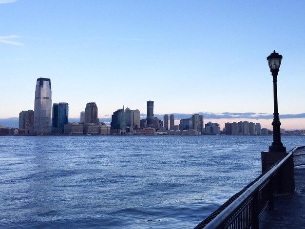 City at waterfront against blue sky