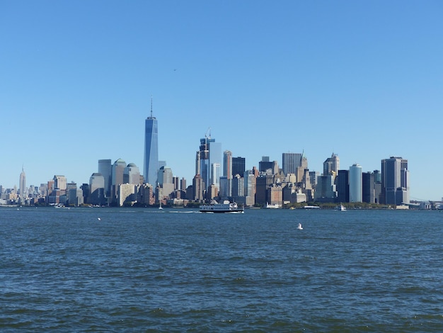 City at waterfront against blue sky