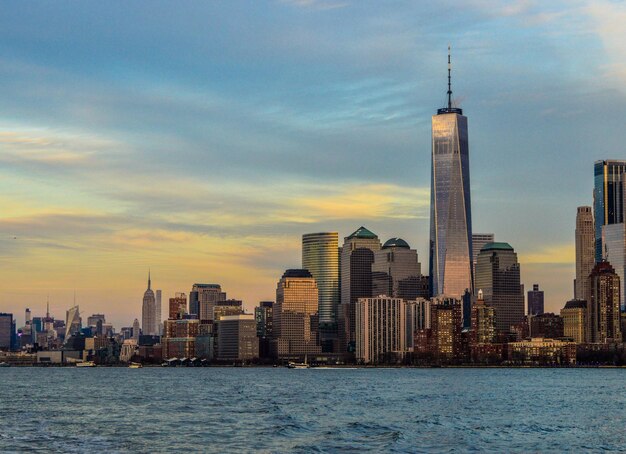 City at waterfront against cloudy sky