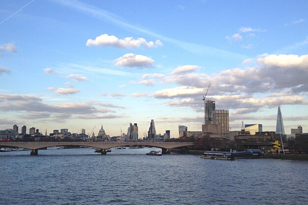 City at waterfront against cloudy sky