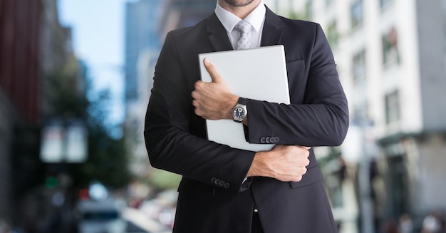 city with businessman holding laptop