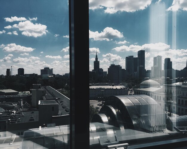 Photo cityscape against sky seen through window