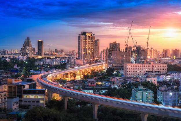 The cityscape bangkok landmark with sky train during sunset