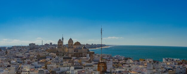 Cityscape by sea against blue sky