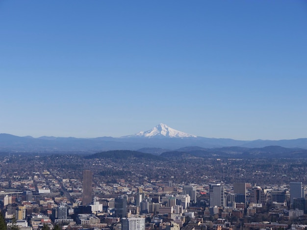 明るい青い空に照らされた雪に覆われた山の都市風景