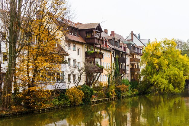 Cityscape from riverside in Nurnberg, river Pegnitz with living houses and trees in Bavarian town, Nuremberg, Germany