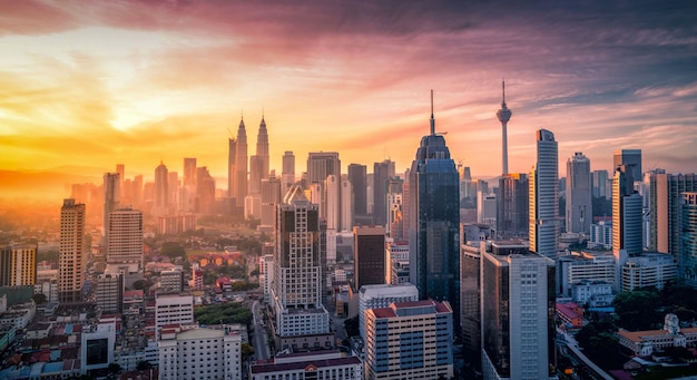 Cityscape of Kuala lumpur city skyline with swimming pool on the roof top of hotel at sunrise in Malaysia.