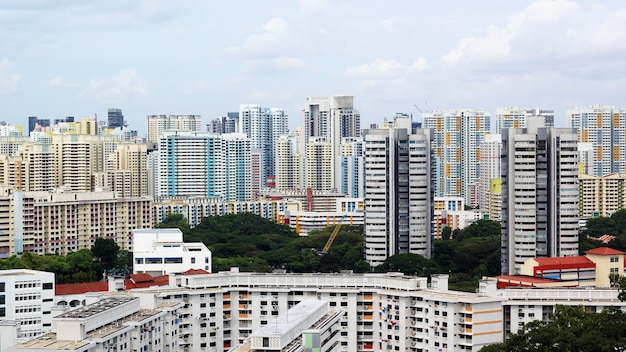 Photo cityscape of many modern tall skyscraper condominiums, apartments, with houses in foreground. buildings, singapore, city area.