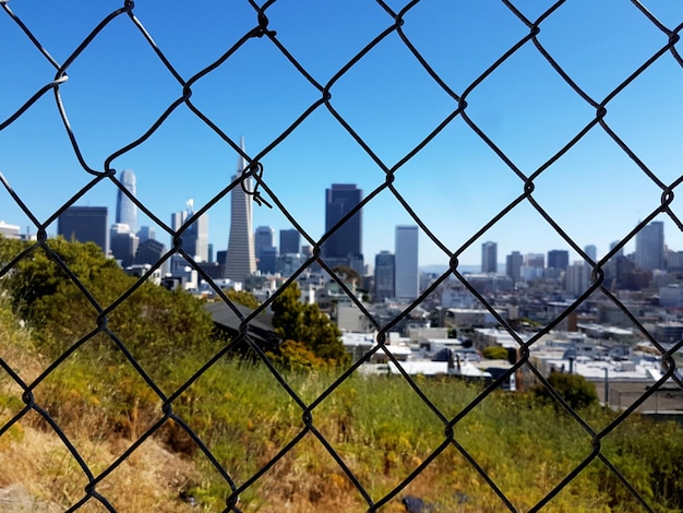 Городской пейзаж через цепной забор