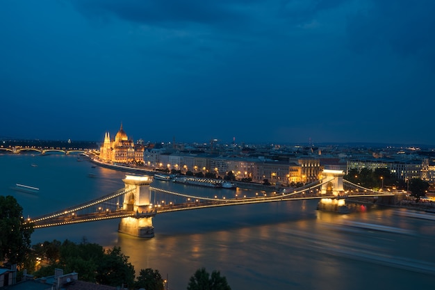 Cityscape view of Danube river at the night with big luminous bridge in Budapest.