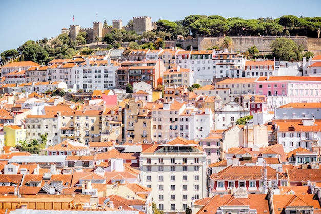 Вид на городской пейзаж на старый город с замковым холмом на горизонте в солнечный день в городе Лиссабон, Португалия