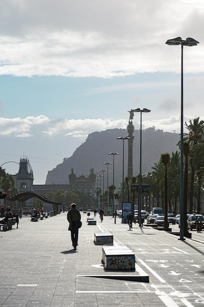 Cityscape view of people walking on sidewalk and road with cars Street view with mountains