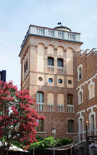 Cityscape with Old building exterior in Italian small city. Ancient tower which serves now as a hotel. Street view in tiny town. Summer vacation. House facade architecture. Mansion structure.