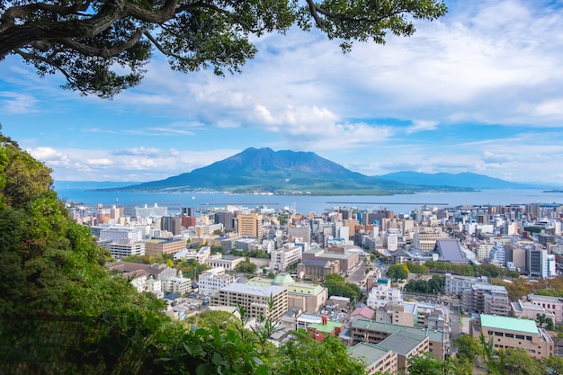 写真 桜島の山、海、青い空を背景に街並み