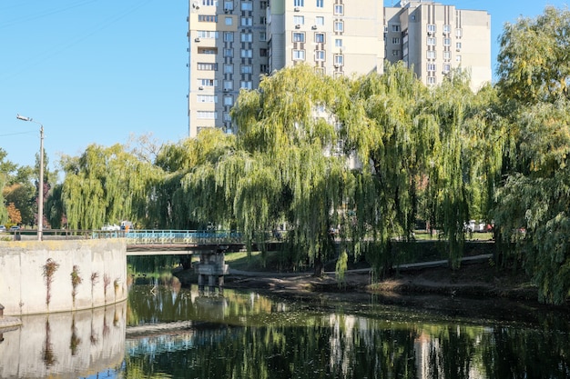 Городской пейзаж с небольшим озером в осенний теплый солнечный день