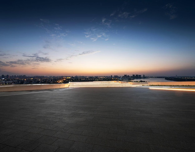 A cityscape with a sunset and a few lights on the ground