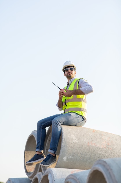 Civiel-ingenieur uit het Midden-Oosten bedient de werknemer op de radio om het werken op de bouwplaats te controleren