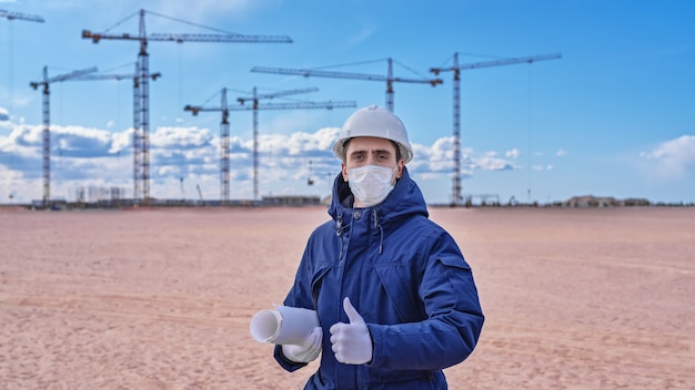Инженер-строитель в белом шлеме и синей куртке на сайте