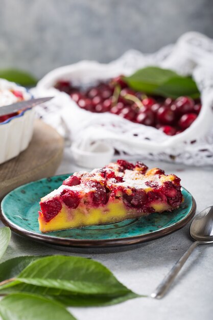 Foto torta di ciliegie clafouti su pietra nera